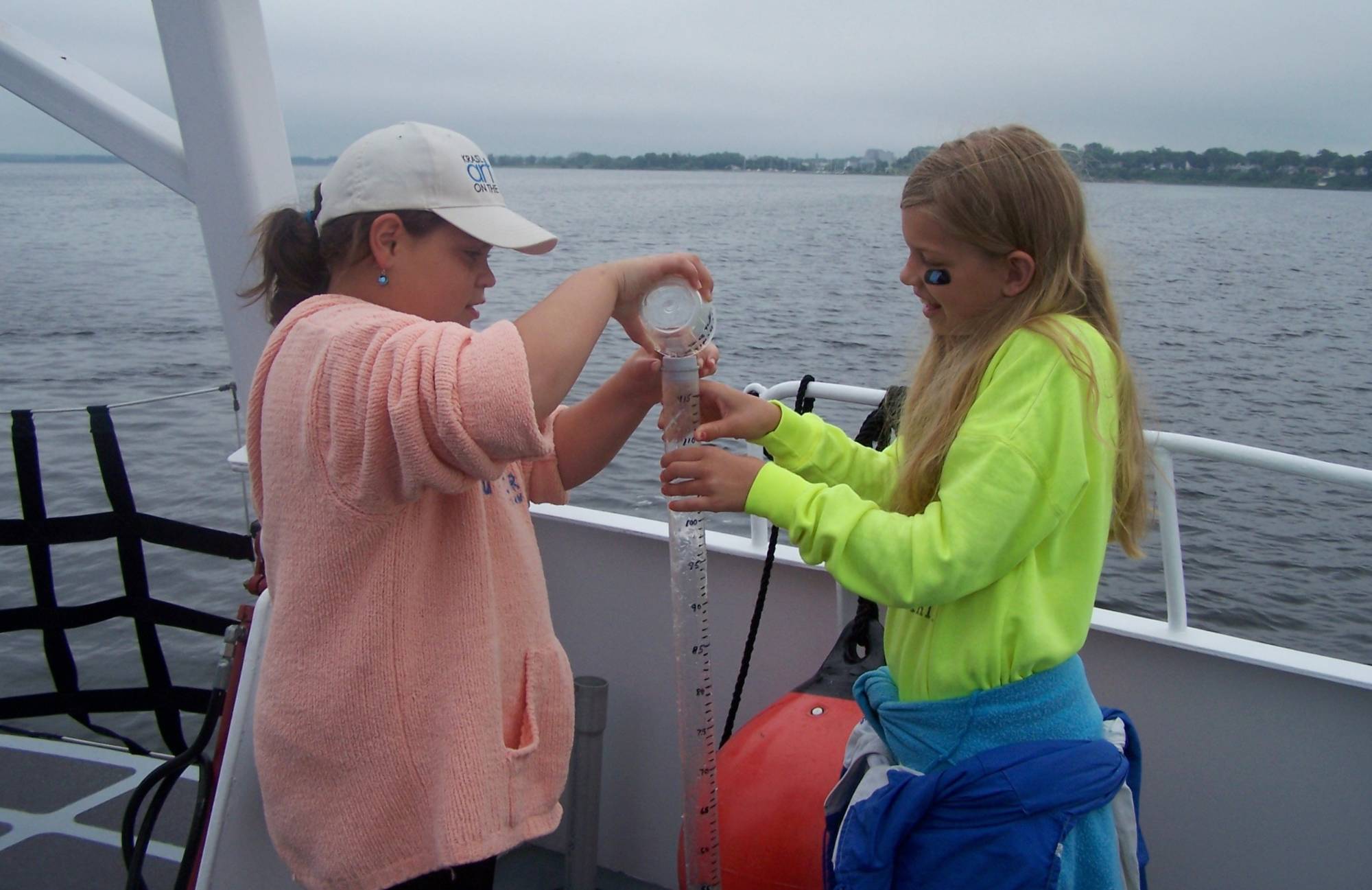 Girls studying water on a research vessel